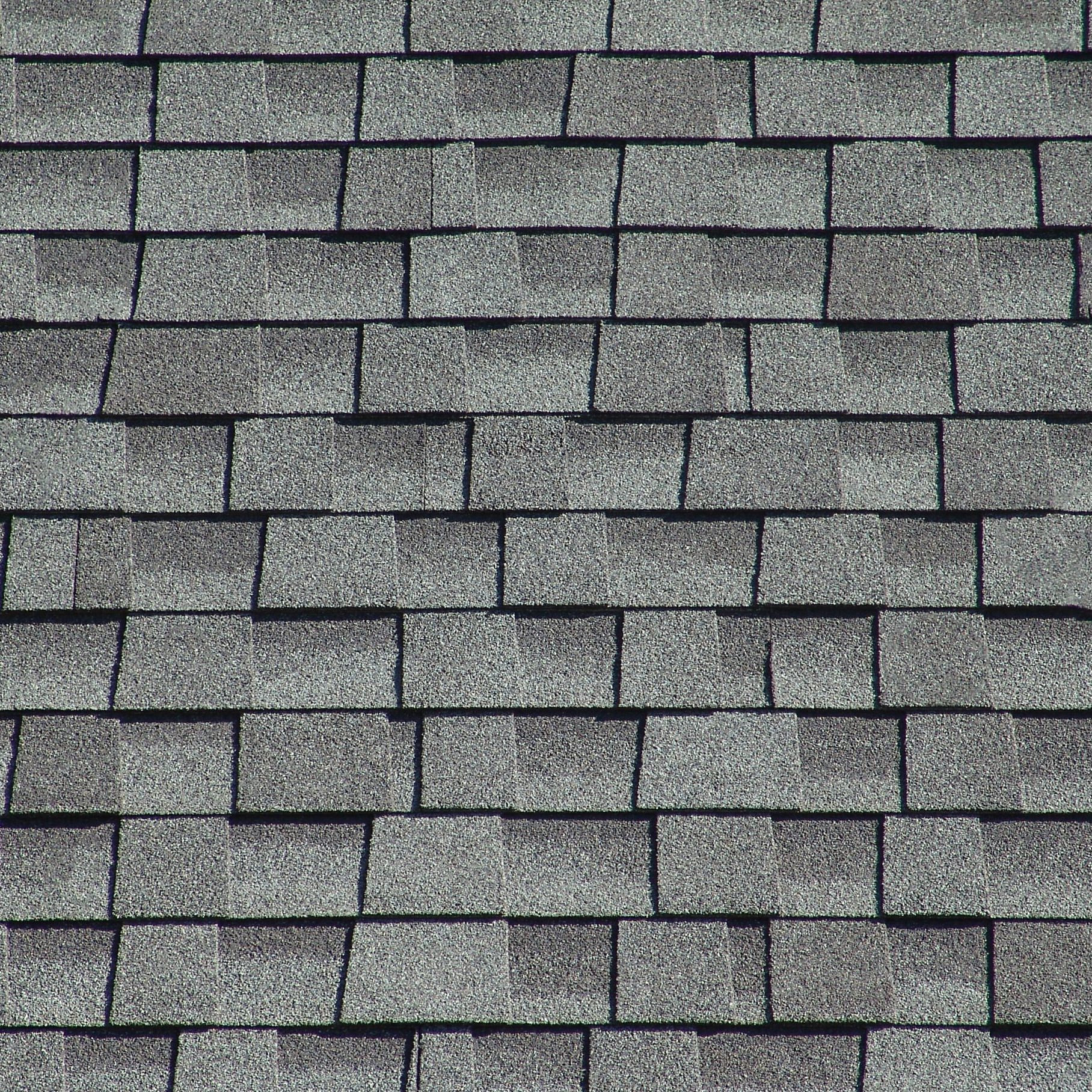 The roof is covered with soft shingles in the form of geometric plates of gray color.Texture and background.